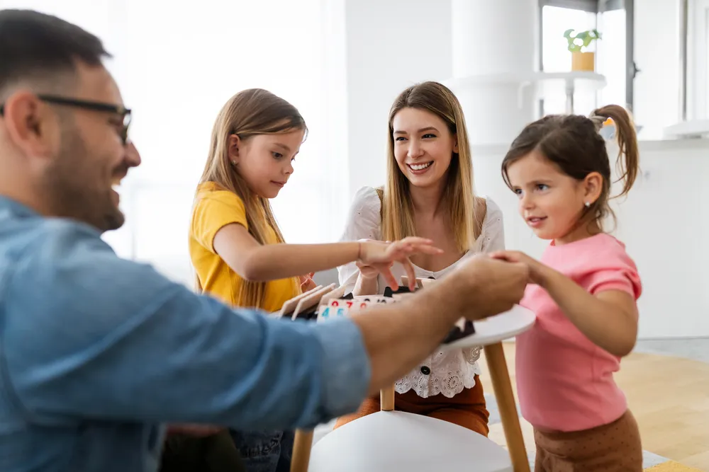 Familia sonriendo y jugando juntos. El desarrollo de Habilidades parentales para una crianza feliz y afectiva
