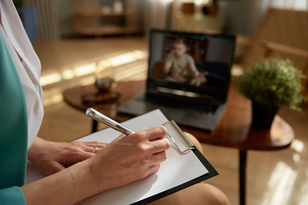 A woman acting as a professional counselor in an emotional support video call with a soldier from her office.